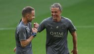 Paris Saint-Germain's Spanish head coach Luis Enrique (R) speaks with a staff member during a training session on the eve of their UEFA Champions League semi-final first leg football match against Borussia Bortmund at the Signal Iduna Stadium in Dortmund, western Germany on April 30, 2024. (Photo by FRANCK FIFE / AFP)