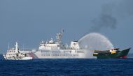 (Files) This photo taken on March 5, 2024 shows China Coast Guard vessels deploying water cannons at the Philippine military chartered Unaizah May 4 (R) during its supply mission to Second Thomas Shoal in disputed waters of the South China Sea. (Photo by Jam Sta Rosa / AFP)
 