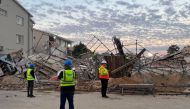 Officials are seen at the scene of a collapsed building in George on May 7, 2024. (Photo by Willie van Tonder / AFP)
