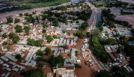 This aerial view shows the damages of a main road and houses submerged in water following heavy floods in Garissa, on May 8, 2024. (Photo by LUIS TATO / AFP)
