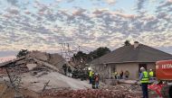 (Files) Rescue workers are seen at the scene of a collapsed building in George on May 7, 2024. (Photo by Willie van Tonder / AFP)

