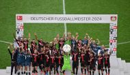 Bayer Leverkusen's Finnish goalkeeper #01 Lukas Hradecky and teammates celebrate with the trophy after the German first division Bundesliga football match between Bayer 04 Leverkusen and FC Augsburg in Leverkusen, western Germany on May 18, 2024. . (Photo by Sascha Schuermann / AFP)