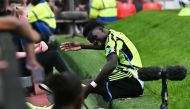 Arsenal's English midfielder #07 Bukayo Saka falls from the pitch during the English Premier League football match between Manchester United and Arsenal at Old Trafford in Manchester, north west England, on May 12, 2024. (Photo by Paul ELLIS / AFP)