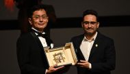 Japanese director and Ghibli Park Creative Development manager Goro Miyazaki is awarded with the Honorary Palme by Spanish director, producer, and writer and member of the Jury of the 77th Cannes Film Festival Juan Antonio Bayona during the 77th edition of the Cannes Film Festival in Cannes, southern France, on May 20, 2024. Photo by LOIC VENANCE / AFP.