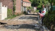 A resident tries to clean the road from debris in the small town of Sailly Lorette, after violent storms and torrential rain hit the north of France, causing homes to flood and mudslides to pour down streets, in Somme department, northern France, on May 22, 2024. (Photo by Denis CHARLET / AFP)
