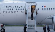 France's President Emmanuel Macron waves as he boards his Presidential aeroplane to travel to the Pacific archipelago of New Caledonia in an attempt to resolve a political crisis, at the Orly airport, suburb of Paris on May 21, 2024. Photo by Ludovic MARIN / POOL / AFP.