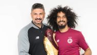 Al Sadd coach Wesam Rizk and striker Akram Afif pose with the Amir Cup trophy.