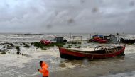 A man pulls a fishing boat to a sea shore as a preventive measure during rainfall in Kuakata on May 26, 2024, ahead of cyclone Remal's landfall in Bangladesh. Cyclone Remal is set to hit the country and parts of neighbouring India on May 26 evening, with Bangladesh's weather department predicting crashing waves and howling gales with gusts of up to 130 kilometres (81 miles) per hour. (Photo by Munir Uz Zaman / AFP)