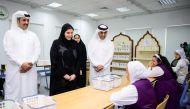 Minister of Labour H E Dr. Ali bin Smaikh Al Marri (right), and Minister of Social Development and Family H E Maryam bint Ali bin Nasser Al Misnad (centre) touring the exhibition.