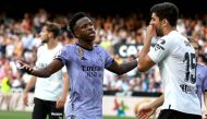 Real Madrid's Brazilian forward Vinicius Junior (L) talks to Valencia's Turkish defender Cenk Ozkacar as he reacts to being insulted from the stands during the Spanish league football match between Valencia CF and Real Madrid CF at the Mestalla stadium in Valencia on May 21, 2023. Photo by JOSE JORDAN / AFP.