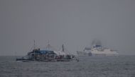 A China Coast Guard ship (R) sailing past a Philippine fishing boat with volunteers from the civilian-led mission Atin Ito (This Is Ours) Coalition on board, in the disputed South China Sea on May 15, 2024. (Photo by Ted ALJIBE / AFP)
