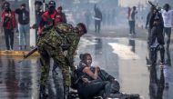 A protester cries on the ground while bracing next to another protester after being srpayed by a police water canon truck during a demonstration against tax hikes as Members of the Parliament vote the Finance Bill 2024 in downtown Nairoibi, on June 20, 2024. (Photo by LUIS TATO / AFP)
