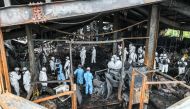 Emergency personnel and investigators examine the site the day after a fire at a lithium battery factory owned by South Korean battery maker Aricell in Hwaseong on June 25, 2024. (Photo by YONHAP / AFP) 
