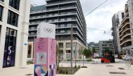 This photograph shows a direction sign at site of the Olympic village where the athletes will be housed in Saint-Denis, a nearby suburb of Paris, on July 2, 2024. (Photo by EMMANUEL DUNAND / AFP)