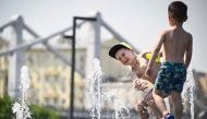 Children play in a fountain during a midday heat in central Moscow on July 3, 2024. (Photo by Alexander NEMENOV / AFP)
