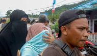 Family members of a victim weep upon finding out about the landslide in Bone Bolango Regency on July 8, 2024. (Photo by Didot / AFP)