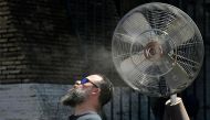 A fan sprays water along the gates of the Colosseum to refresh tourists on July 11, 2024 in Rome where temperatures reach 38 degrees celsius today. (Photo by Tiziana FABI / AFP)