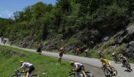UAE Team Emirates team's Slovenian rider Tadej Pogacar wearing the overall leader's yellow jersey cycles with the pack of riders (peloton) during the 15th stage of the 111th edition of the Tour de France cycling race, 197,7 km between Loudenvielle and Plateau de Beille, in the Pyrenees mountains, southwestern France, on July 14, 2024. (Photo by Thomas SAMSON / AFP)
