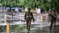 Bangladesh army personnel keep a vigil near barbed wire barricades amid a curfew following clashes between police and protestors, in Dhaka on July 22, 2024. (Photo by Munir Uz Zaman / AFP)