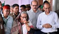 In this handout photograph taken and released on July 25, 2024 by Bangladesh Prime Minister's Office, Prime Minister Sheikh Hasina (C) weeps while she visits a metro station in Mirpur vandalized by students during the anti-quota protests. 