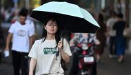 A woman walks during a hot day in Wuhan, central China's Hubei province on August 1, 2024. (Photo by Pedro Pardo / AFP)
 
