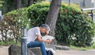 A man uses a folding fan at the Odaiba Seaside Park in Tokyo on July 26, 2024. (Photo by Yuichi Yamazaki / AFP)
