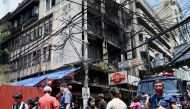 People, policemen, and media personnel are seen at the scene of a fire that ripped through a building in Manila's Chinatown on August 2, 2024. (Photo by Jam Sta Rosa / AFP)
