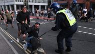 A police dog bites a protester in Bristol, southern England, on August 3, 2024 during the 'Enough is Enough' demonstration held in reaction to the fatal stabbings in Southport on July 29. Photo by JUSTIN TALLIS / AFP