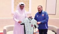 Minister of Sports and Youth H E Sheikh Hamad bin Khalifa bin Ahmed Al Thani receives a jersey from Chairman of the QFA’s Referees Committee Hani Taleb Ballan.  