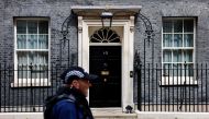 A police officer passes the door to 10 Downing Street, the official residence of Britain's Prime Minister, in central London on August 5, 2024. (Photo by BENJAMIN CREMEL / AFP)

