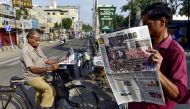 A man (R) reads a newspaper with an article on Bangladesh published on its front page, along a street in Jalandhar on August 6, 2024, a day after Bangladesh's Prime Minister Sheikh Hasina was ousted by anti-government protestors. Photo by Shammi MEHRA / AFP