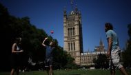 People play in the sunshine in Victoria Tower Gardens near the Houses of Parliament, in central London, on July 30, 2024. (Photo by HENRY NICHOLLS / AFP)