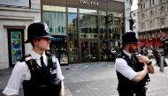 A photograph taken on August 12, 2024 shows police officers standing by a cordoned off area in Leicester square, London. Photo by BENJAMIN CREMEL / AFP.