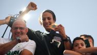 Algerian gold medallist Imane Khelif greets crowds during a bus tour in her hometown city of Tiaret on August 16, 2024. (Photo by AFP)