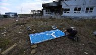 This photograph taken on 16 August, 2024, during a media tour organised by Ukraine, shows a man examining a damaged road sign.