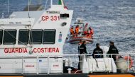 Italian Coast Guards carry a body on a rescue boat in Porticello harbor near Palermo, with a third body at the back of the boat on August 21, 2024, two days after the British-flagged luxury yacht Bayesian sank. (Photo by Alberto PIZZOLI / AFP)
