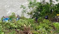 Rescue personnel gather at the site after a bus carrying Indian passengers plunged into the Marsyangdi river in Nepal's Tanahun district on August 23, 2024. (Photo by SHANKHAR ADHIKARI / AFP)
