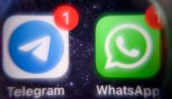 This picture taken on March 23, 2022 shows the mobile messaging and call service Telegram logo and US instant messaging software Whatsapp logo on a smartphone screen in Moscow. Photo by AFP.