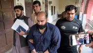 Farhan Asif (2R), who was arrested allegedly over cyber terrorism, is escorted by Pakistan's Federal Investigation Agency (FIA) personnel after his acquittal from a court in Lahore on August 26, 2024. (Photo by Arif ALI / AFP)
