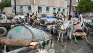 Sudanese queue to fill on water Port Sudan on August 26, 2024, after a dam collapsed as a result of heavy rain. (Photo by Ibrahim ISHAQ / AFP)
