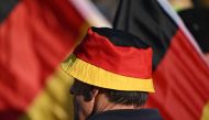 A supporter wears a hat in the colors of the German national flag on August 29, 2024 in the historic center of Dresden, eastern Germany during a campaign event of the far-right Alternative for Germany party (AfD) for the upcoming Saxony state elections. Photo by RALF HIRSCHBERGER / AFP.