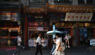 People walk along the Dazhalan street in Beijing on August 29, 2024. (Photo by ADEK BERRY / AFP)
