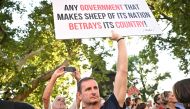 A demonstrator holds a banner as teachers, students and their sympathisers protest in central Budapest at the headquarters of the Interior Ministry on September 2, 2024, after the head of the renowned Madach Imre high school was sacked last week for not implementing a government-mandated 
