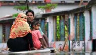 A family uses a makeshift raft to make their way through the flood waters in Daganbhuiyan in Feni, on August 25, 2024. (Photo by Munir Uz Zaman / AFP)
