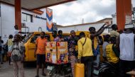 People wait to refill their jerrycans and fuel tanks at a fuel station in Lagos on September 4, 2024. (Photo by FAWAZ OYEDEJI / AFP)
