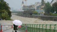 A pedestrian looks at the high level of the Wien river in Hutteldorf, Vienna, during heavy rainfall on September 15, 2024. (Photo by Georg Hochmuth / APA / AFP)
