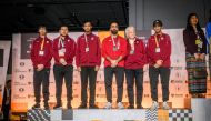 Members of Qatar chess squad pose on the podium. 