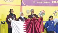Qatar's Kholoud Al Khalaf, Amna Al Abdullah and Maitha Al Binali celebrate on the podium after winning the  silver medal in women’s trap team category. 