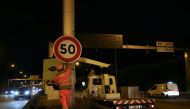 Construction workers install a 50km/h speed limit sign on Paris' ring road, the boulevard peripherique, at the Porte d'Ivry in Paris, on September 30, 2024. Photo by Thomas SAMSON / AFP