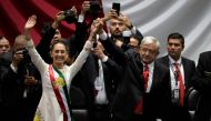 Mexico's new President Claudia Sheinbaum (left) and outgoing Mexican President Andres Manuel Lopez Obrador wave to the attendees during the inauguration ceremony at the Congress of the Union in Mexico City on October 1, 2024. (Photo by Alfredo Estrella/ AFP)